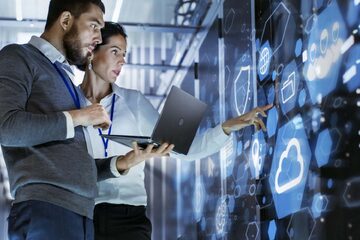 Two business individuals inspecting technology and servers